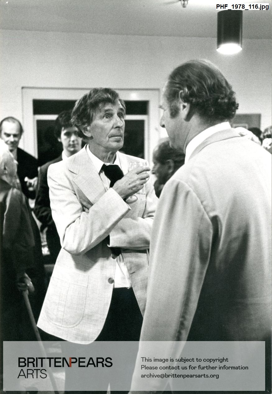 Photograph of Sir Michael Tippett talking to Norman Del Mar at reception
