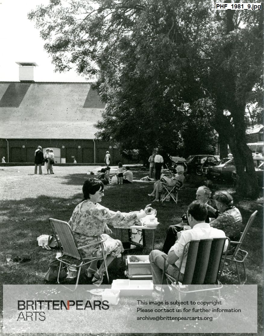 Photograph of audience members picnicing outside Snape Maltings Concert Hall