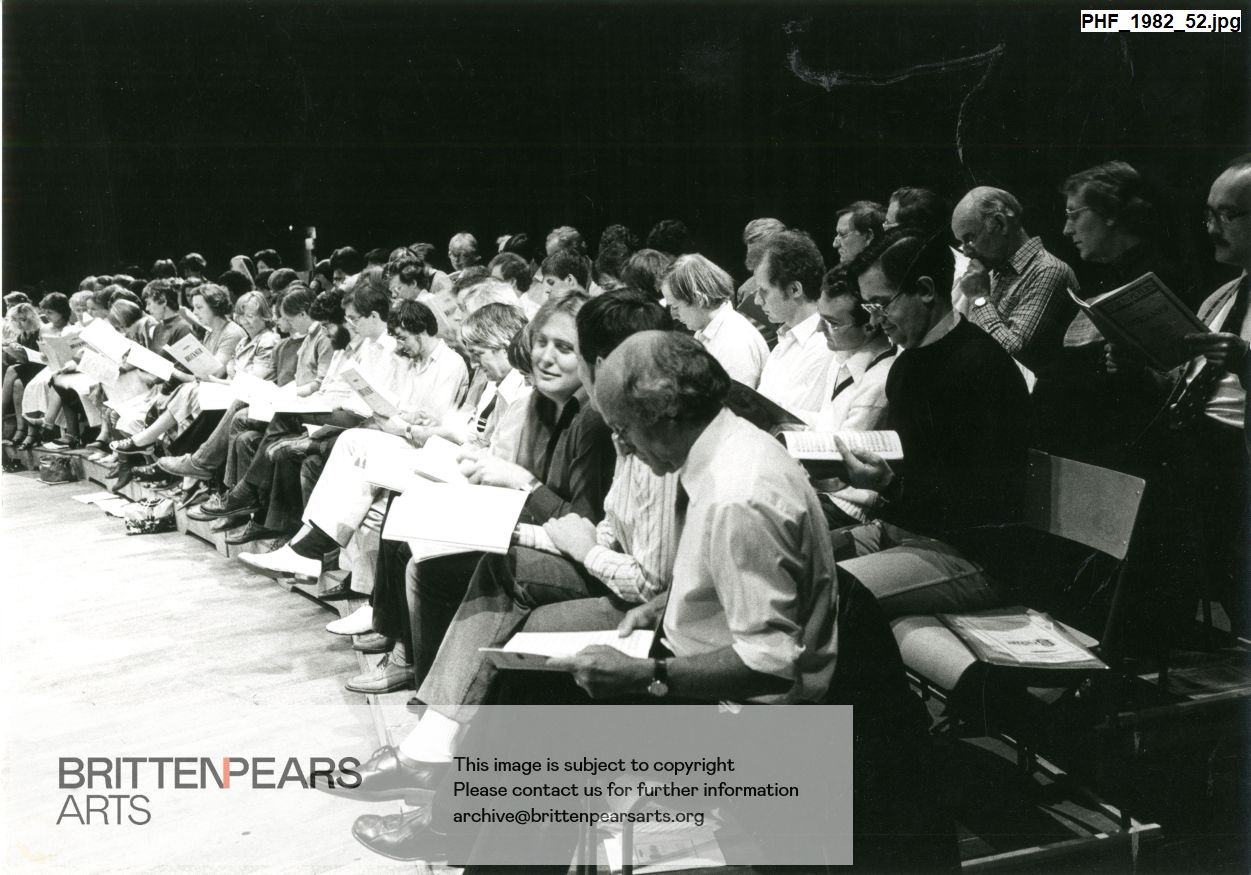 Photograph of choir with scores sitting with scores