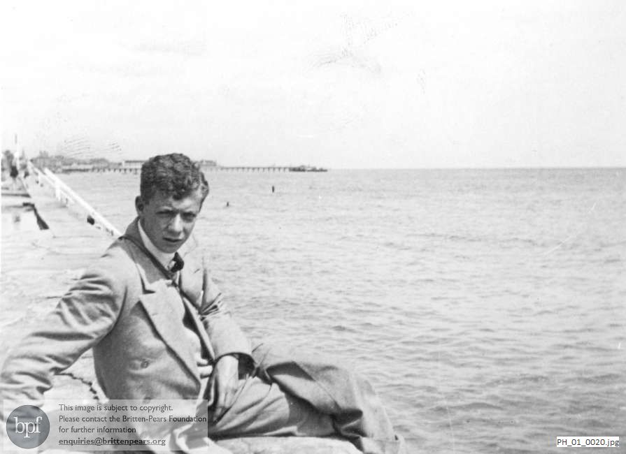 Benjamin Britten sitting on sea wall at Lowestoft