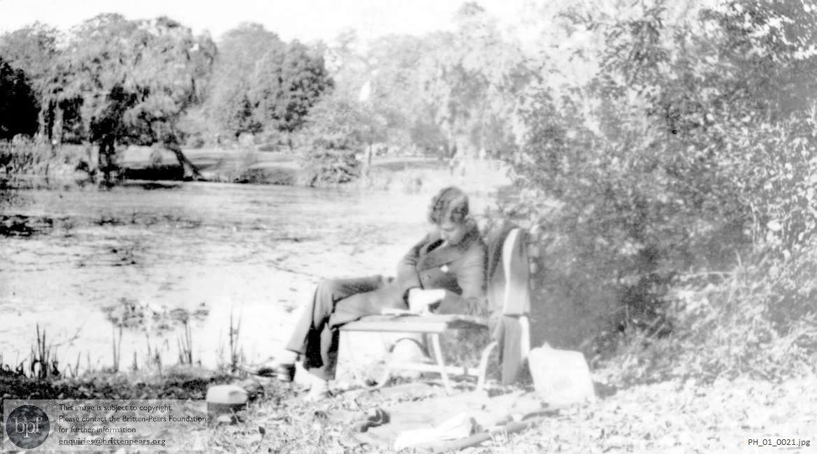 Benjamin Britten reading by a river