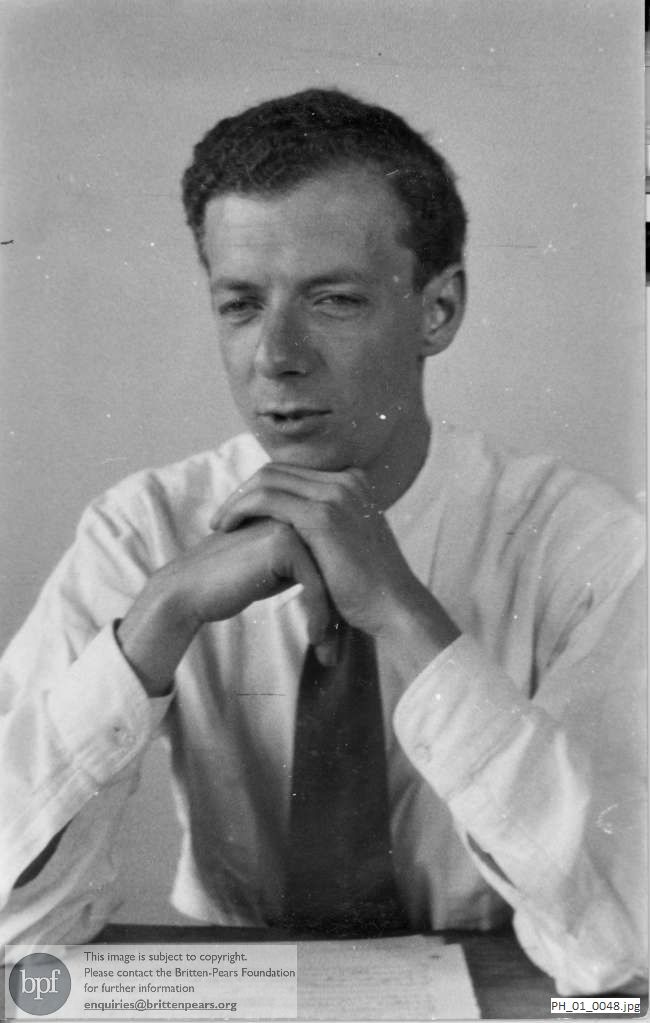 Benjamin Britten seated at a table