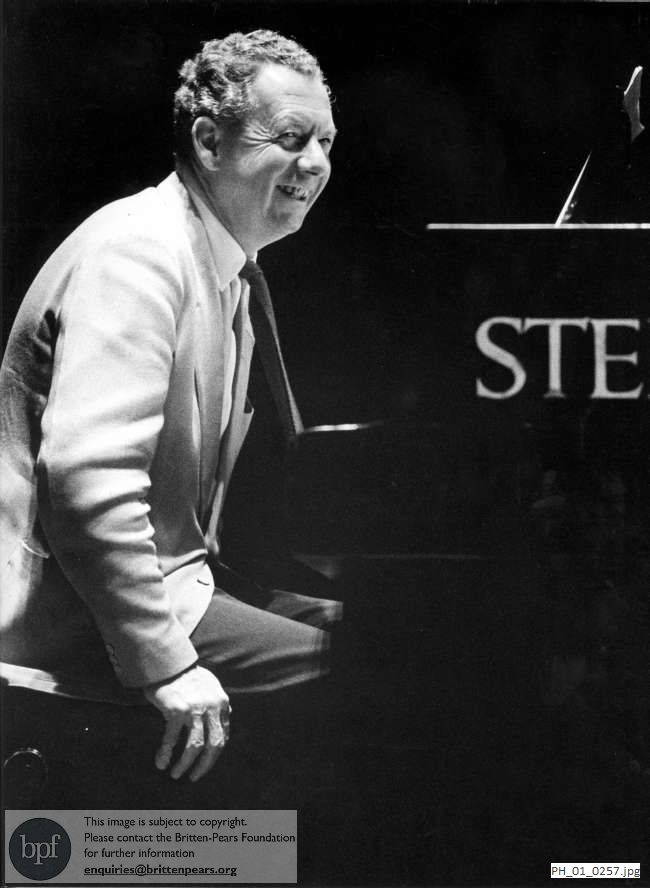 Benjamin Britten seated at a Steinway piano