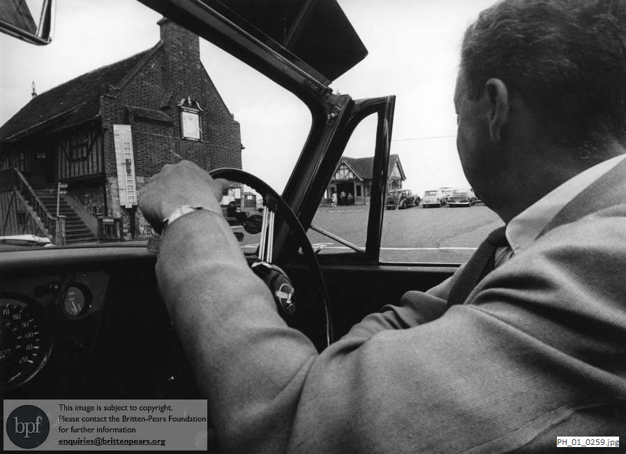 Benjamin Britten driving his car by the Moot Hall in Aldeburgh