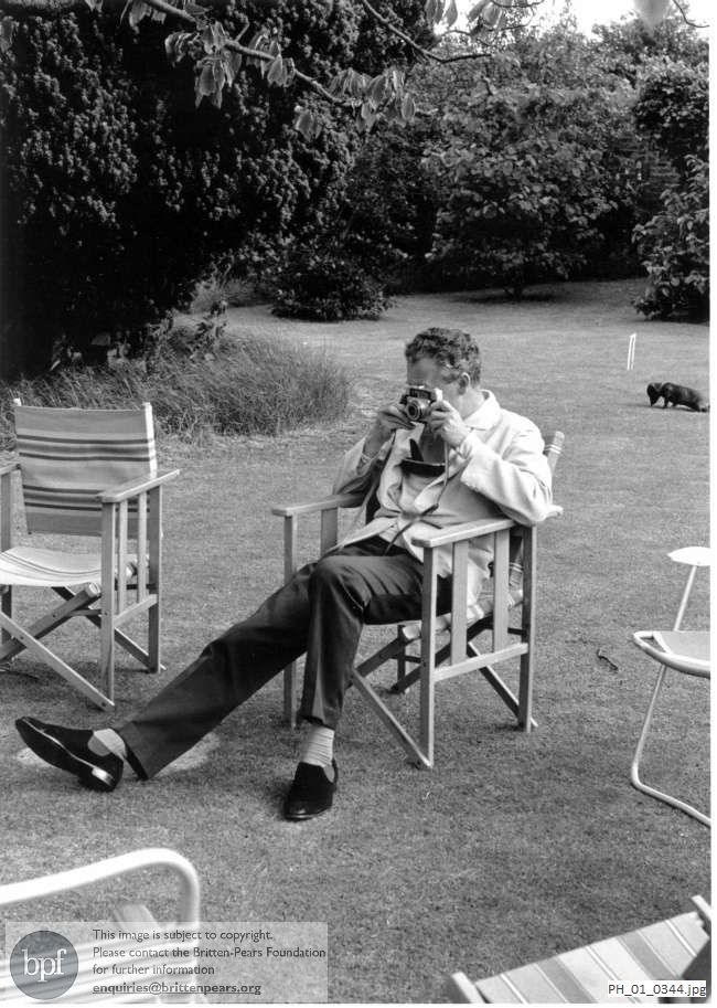 Benjamin Britten taking a photograph in the Red House garden, Aldeburgh