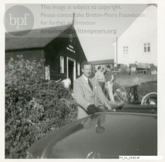 Benjamin Britten standing by his car