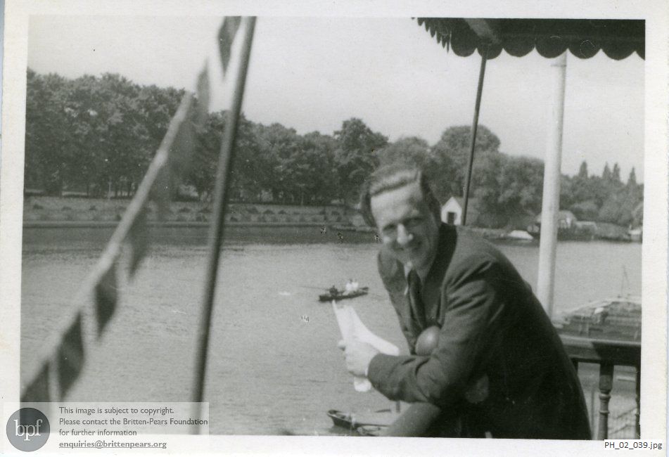 Peter Pears on a riverside balcony
