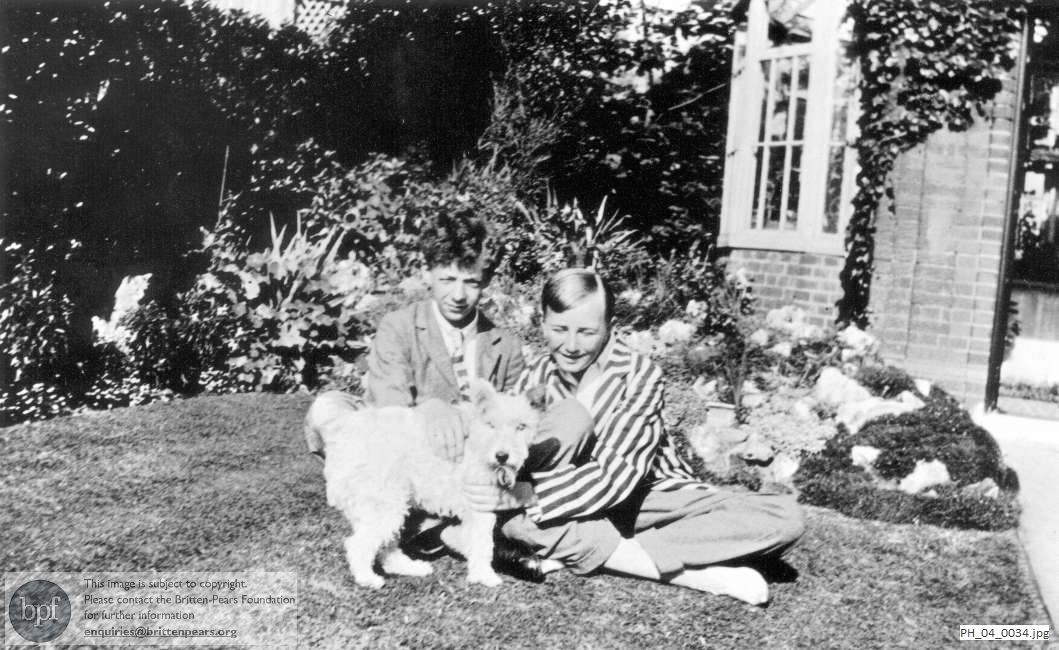 Benjamin Britten with John Pounder and a dog in the front garden at home