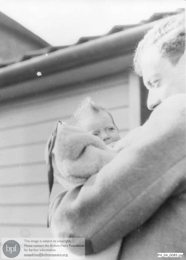 Benjamin Britten holding a baby